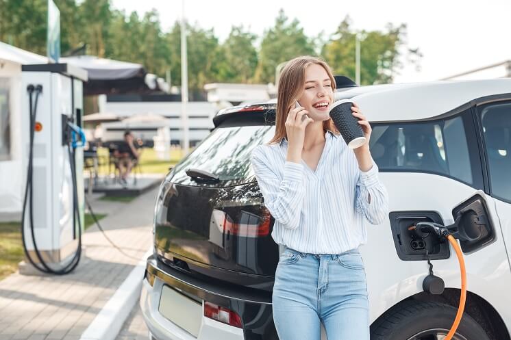 woman charging electric car