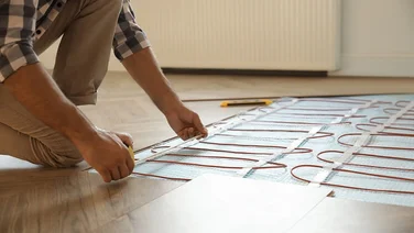 someone installing underfloor heating