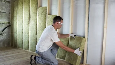 professional installs solid wall insulation using a stud wall