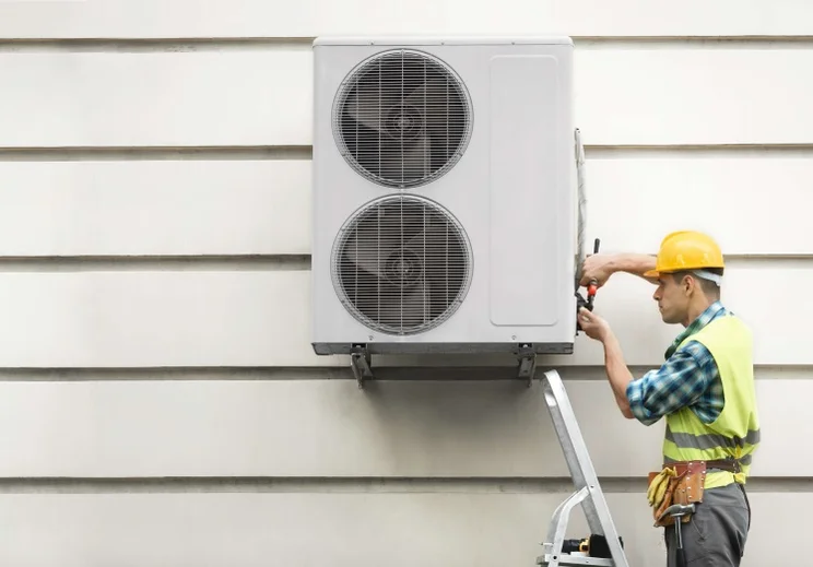 man installing a heat pump