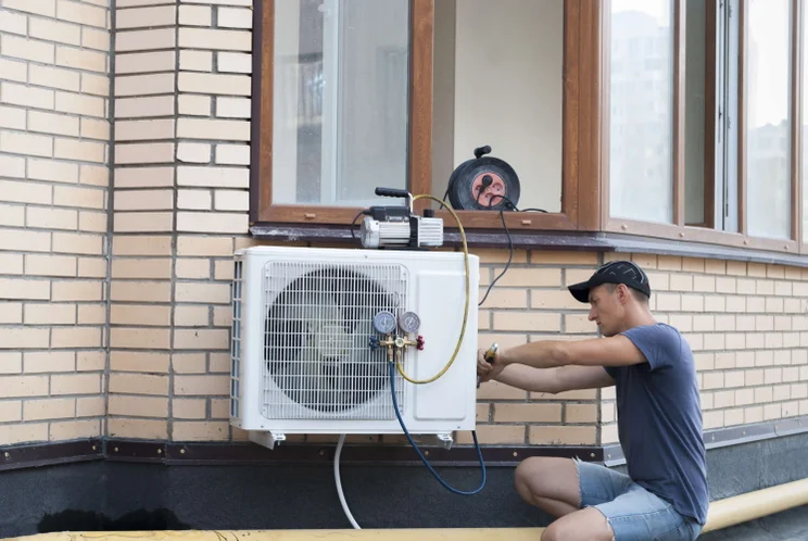 person installing a heat pump