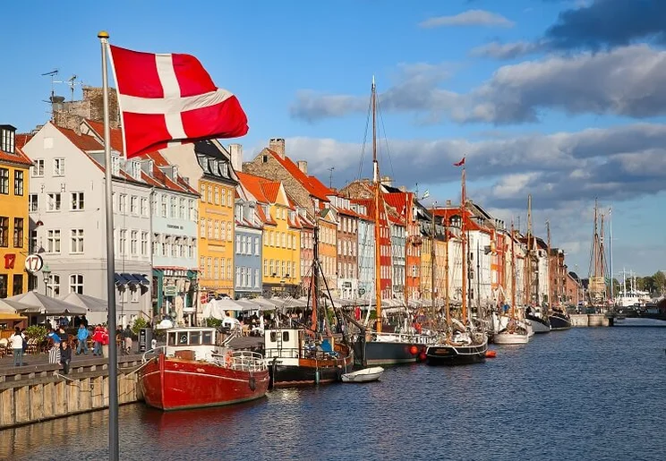 Nyhavn district in Copenhagen, Denmark, colourful houses by port with boats docked