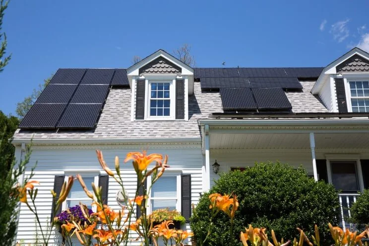 house with solar panels under a blue sky