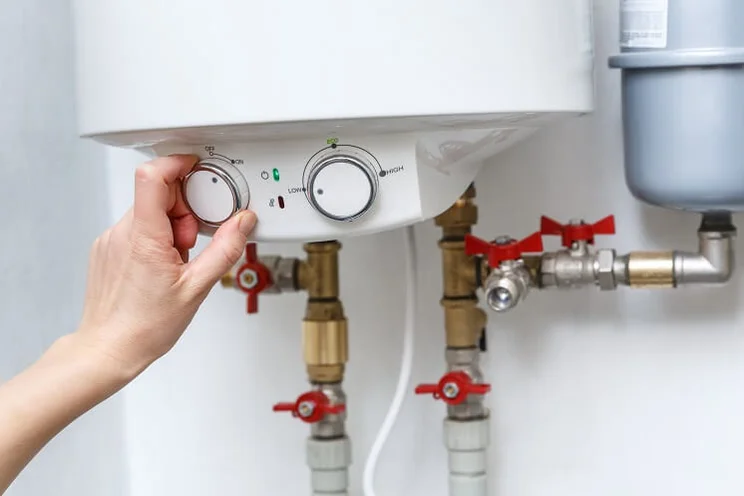 Someone changing the dials on an electric boiler