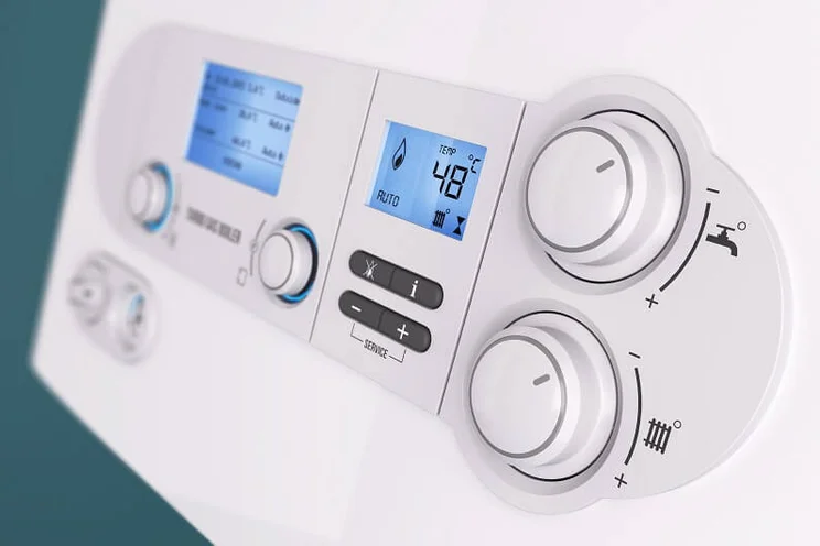 Close up of a gas boiler interface, with dials for hot water and heating
