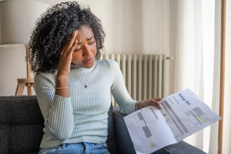woman looking crestfallen at energy bill