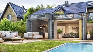 A house with solar panels on the roof open patio with sofas on it and a swimming pool