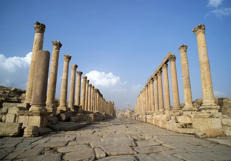 A view looking down the Cardo showing stone carved columns and paved street at the ancient Roman city of Jarash or Gerasa, Jerash in Jordan