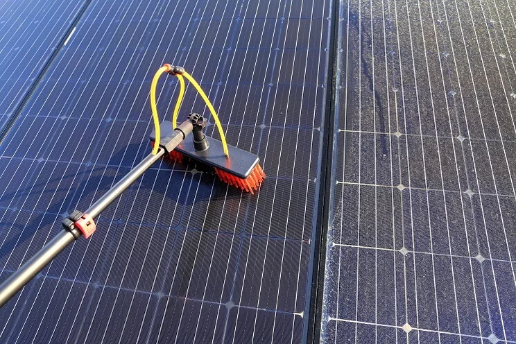 solar panels being cleaned with a brush and water