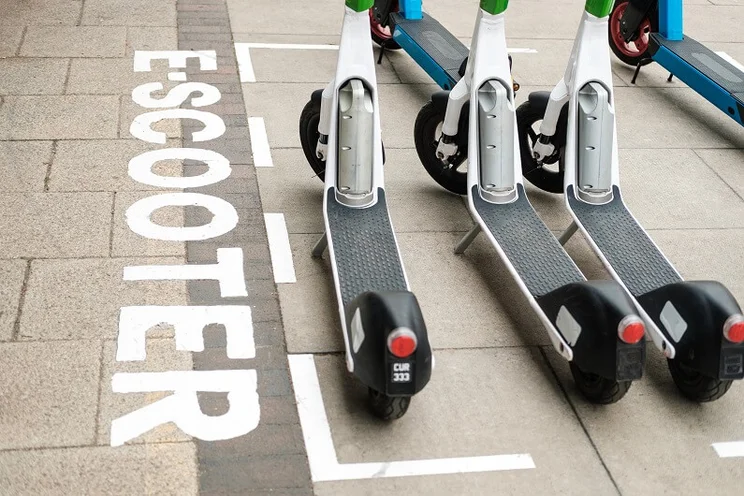 Electric scooter parking bay in London , with three e-scooters parked