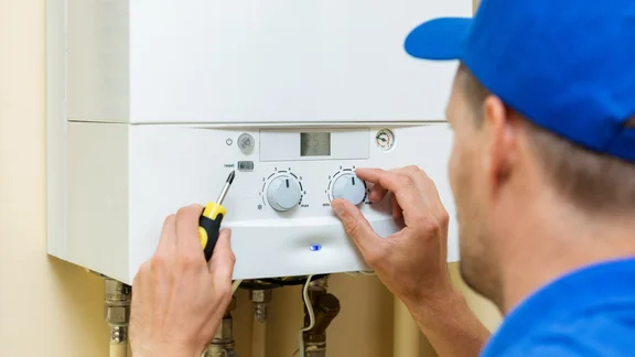 Man adjusting a gas boiler