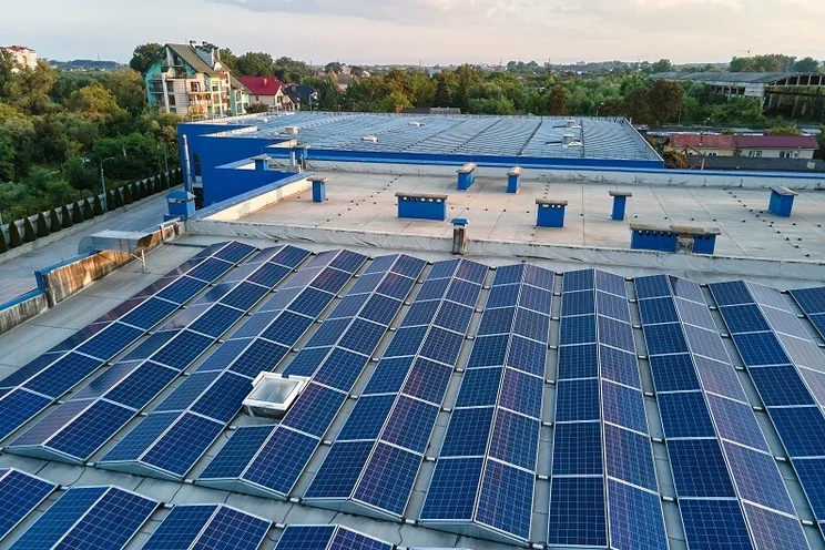 Solar panels covering a large warehouse in an urban environment