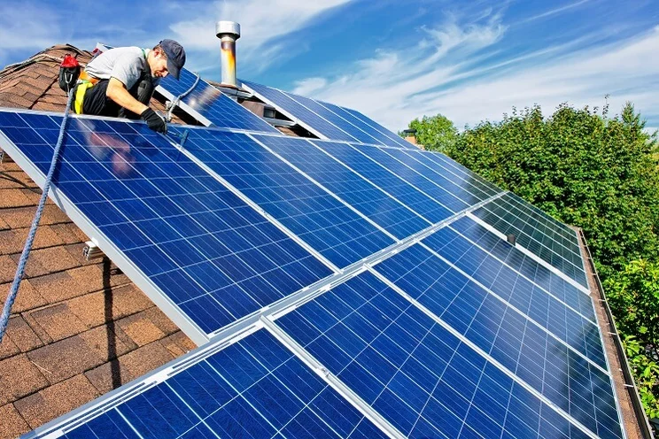 Man on roof installing solar panels