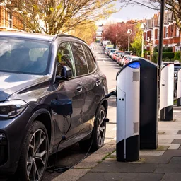 An EV being charged on a residential street