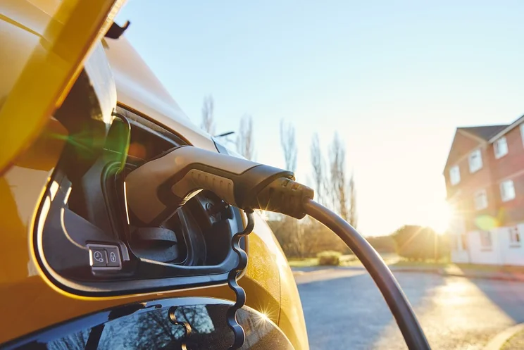 Electric car EV plugged in outside house