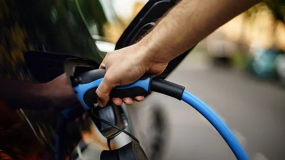 Person using EV charger connected to car