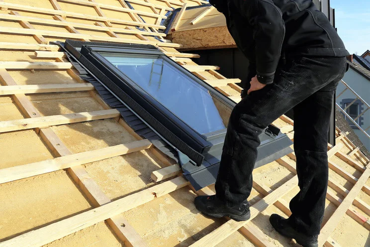 Man installing skylights on a roof