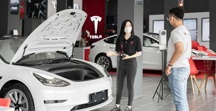 Person looking at a new EV in a showroom.