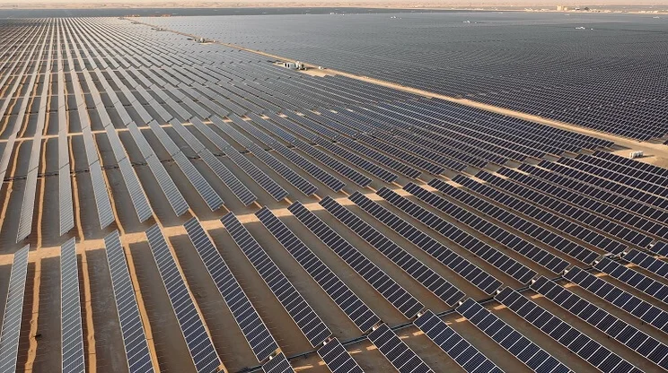 rows of solar panels in a large solar farm in the desert