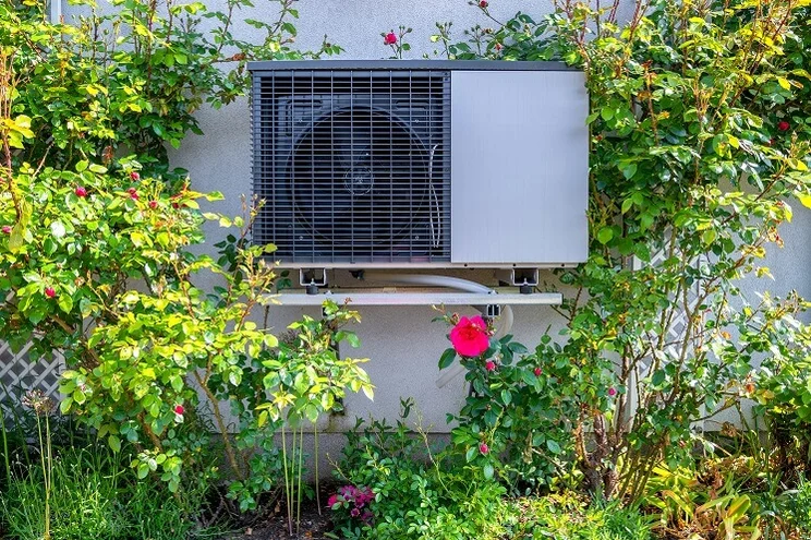 ground source heat pump attached to wall in rose garden