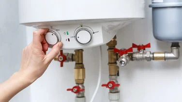 Someone changing the dials on an electric boiler
