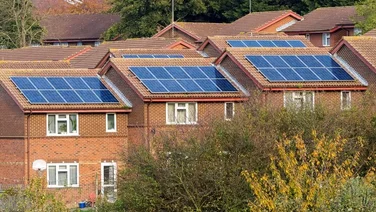 A row of three brown houses with solar panels