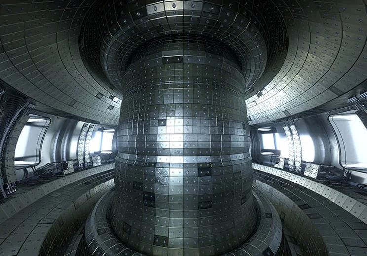 The inside of a fusion reactor. It is made from silvery metal panels and a central column also covered in many small rectangular panels.