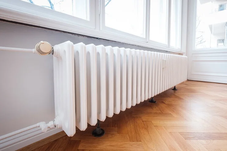 long white radiator on hardwood floor