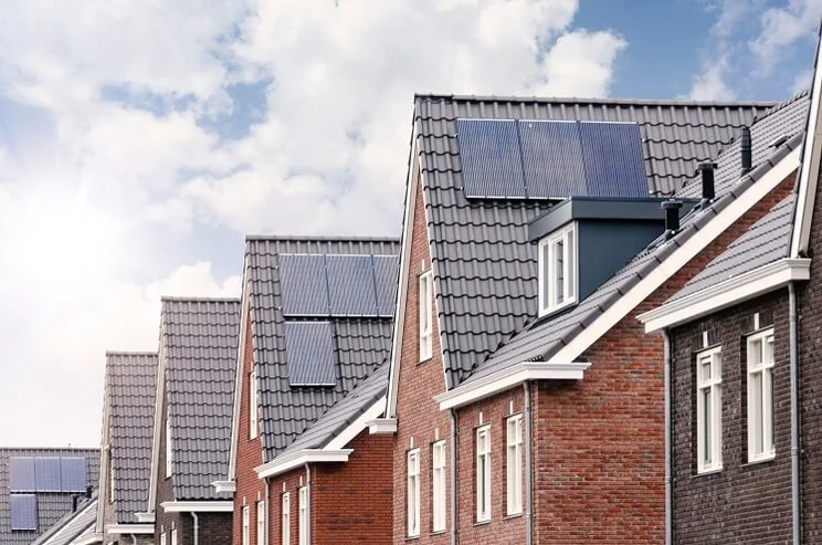 A side view of a row of new build houses with solar panels on the roof