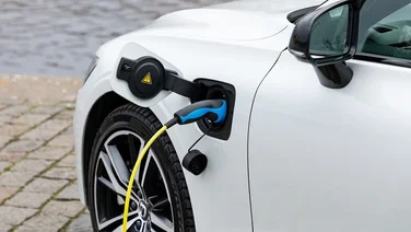 white electric car plugged in to charge