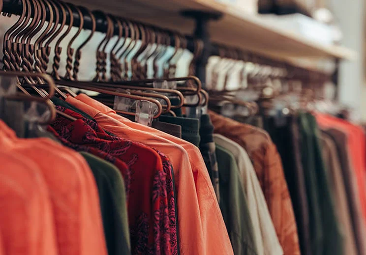 Clothes hanging on a rack, a mixture of autumnal tones.