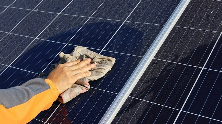 Someone cleaning a dusty panels panel surface with a cloth