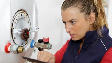female boiler technician works on a boiler