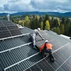 Two men attaching solar panels to a roof