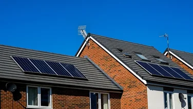 Three homes in the UK with solar panels on their roofs.